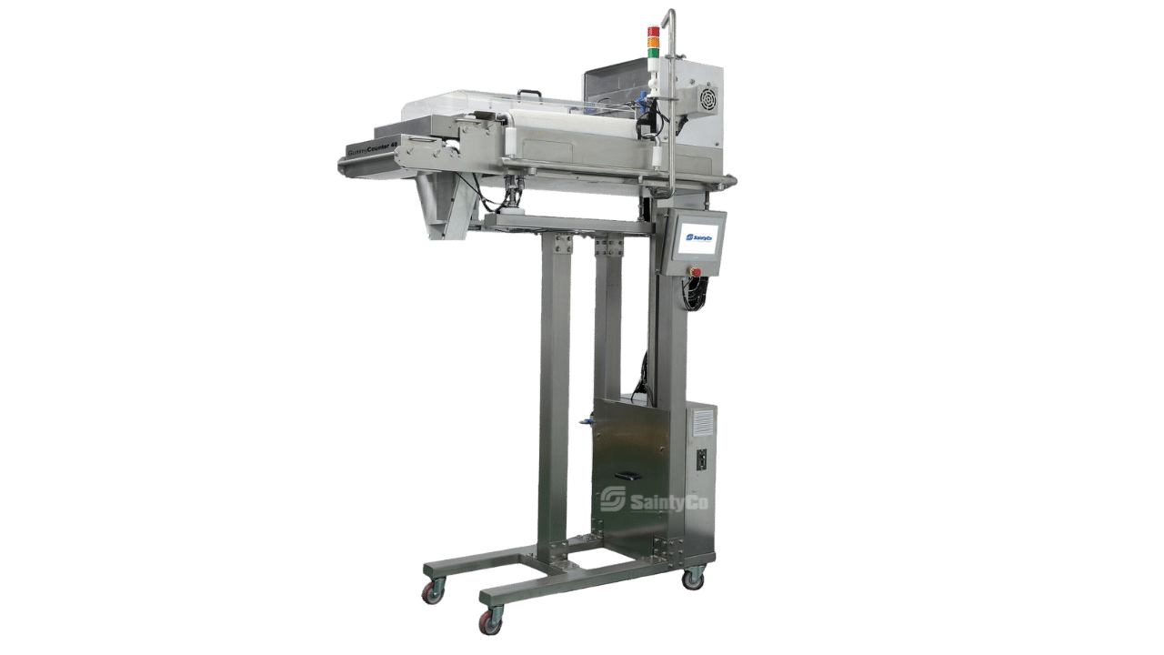 A stainless steel industrial packaging machine with a conveyor belt, control panel, and height-adjustable stand. It has wheels for mobility and appears designed for handling and sealing products in a manufacturing setting. Specifically crafted by SaintyCo, it excels in packaging items like gummy candies.