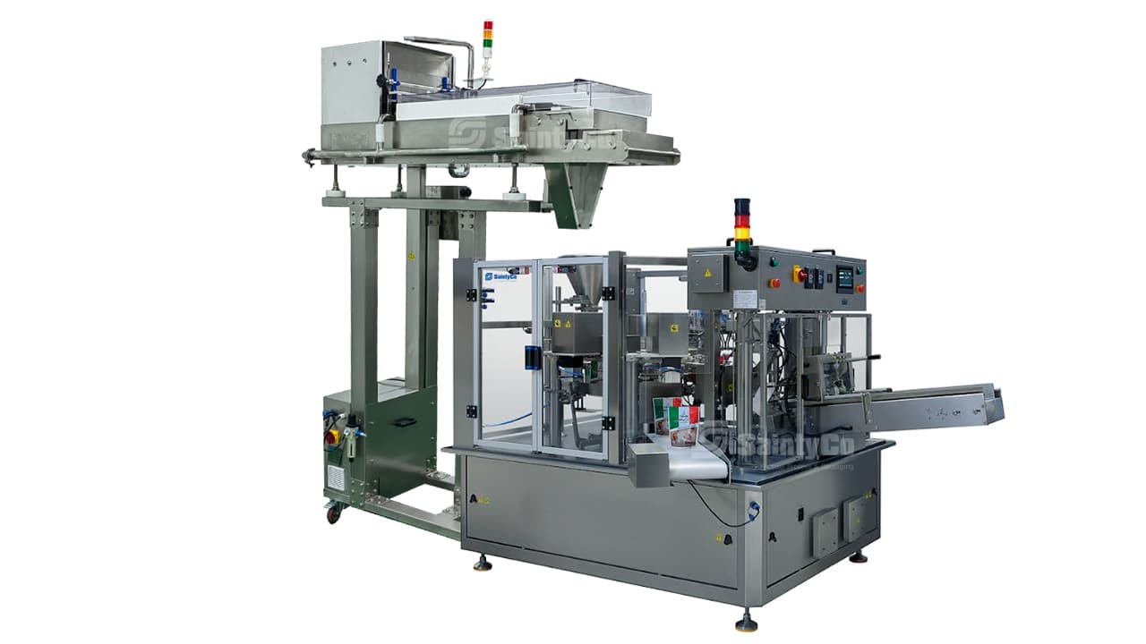 A high-speed packaging machine featuring an automated setup with a conveyor system, multiple dispensing units, and control panels. The SaintyCo design includes vertical loading=