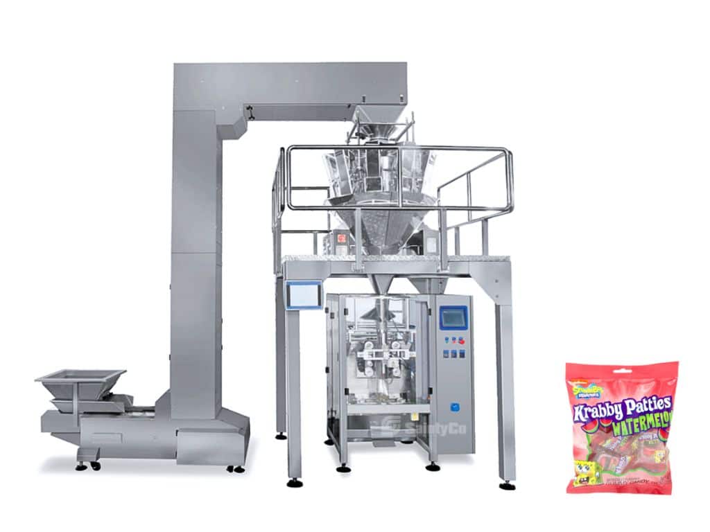 A large industrial packaging machine from SaintyCo is displayed, accompanied by a bag of "Krabby Patties" gummy candies on the right side of the image. The silver machine features various components for the packaging process, highlighting its role as a key piece of gummy manufacturing equipment.