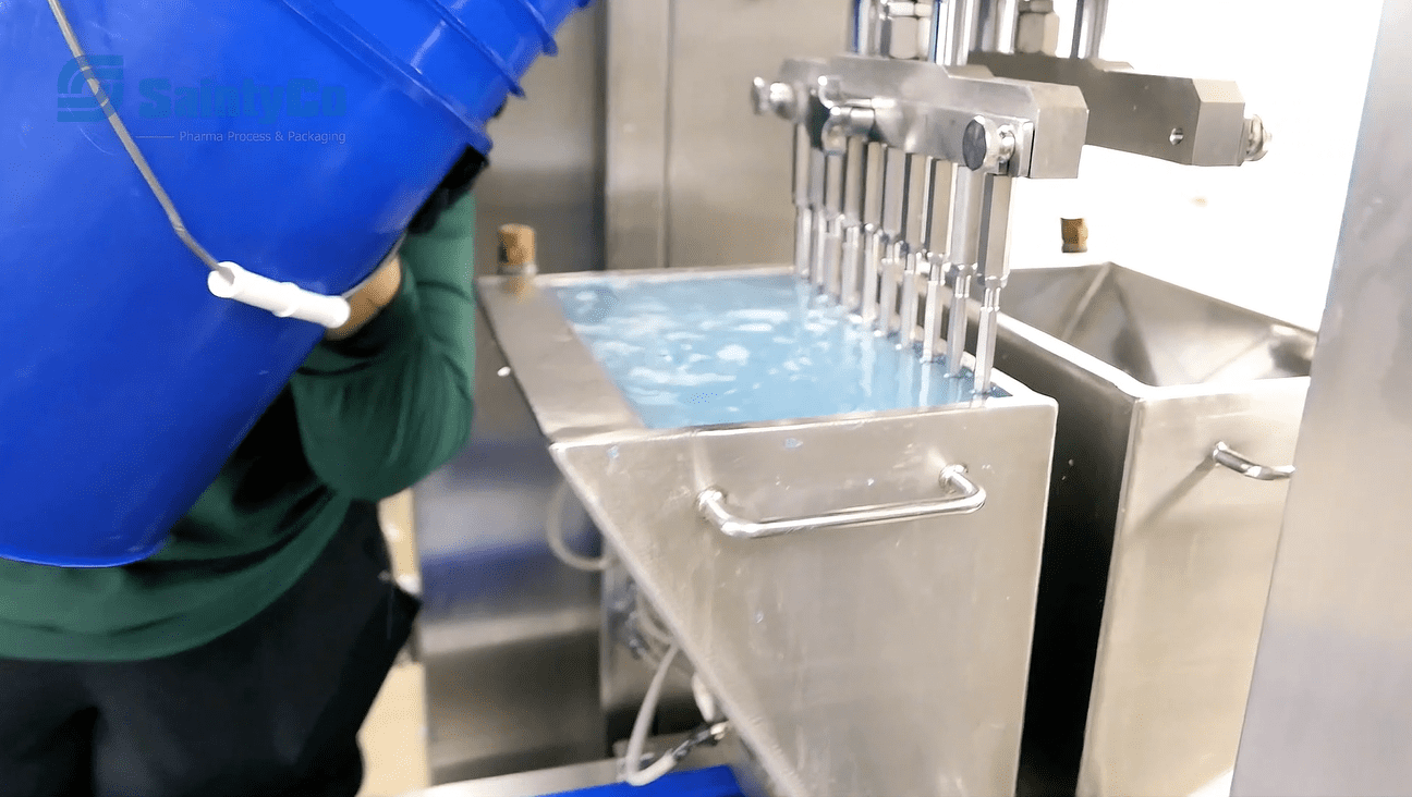 Technician performing maintenance on a gummy depositor machine