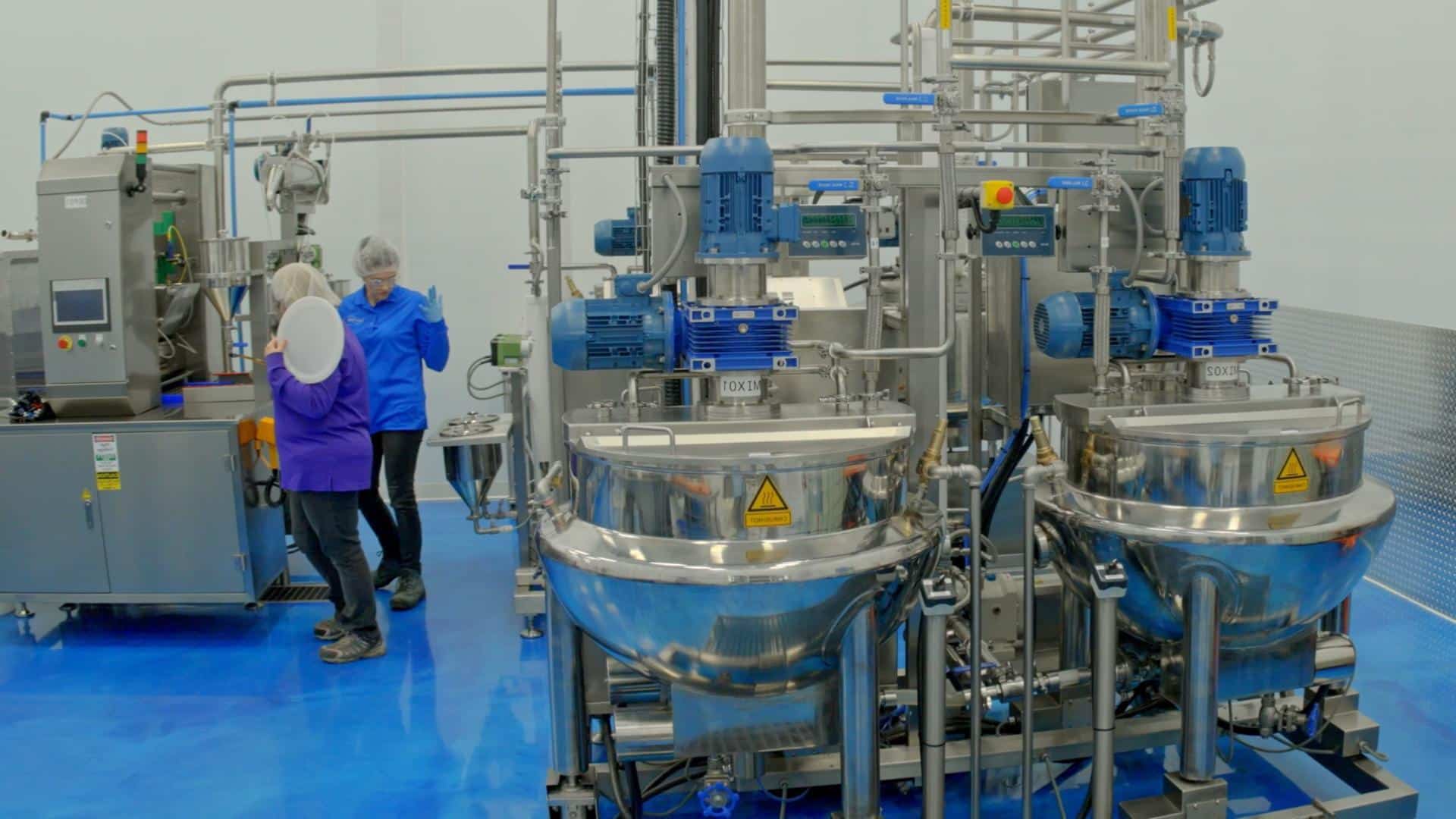 Factory worker checking cannabis gummy production line for safety compliance