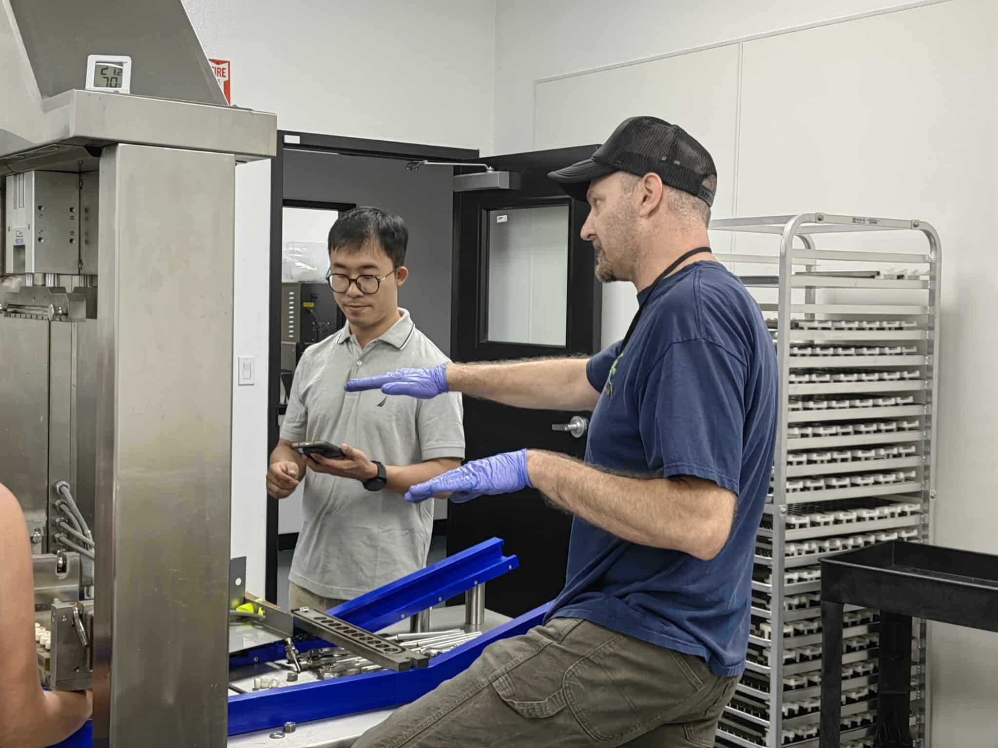 A factory operator adjusting gummy production machinery