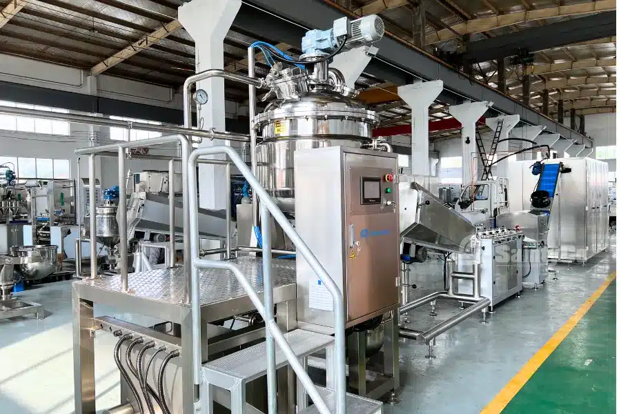 A split image showing industrial candy-making equipment on the left and colorful, round hard candies arranged on a surface with scattered green leaves on the right.